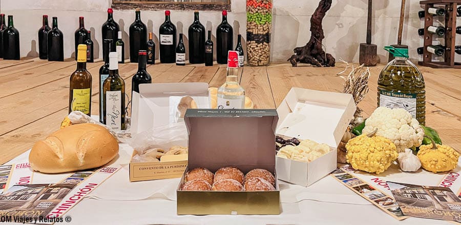 Productos típicos de Chinchón con vino, anís, pan y dulces artesanos sobre una mesa, degustación imprescindible en Chinchón que ver y donde comer