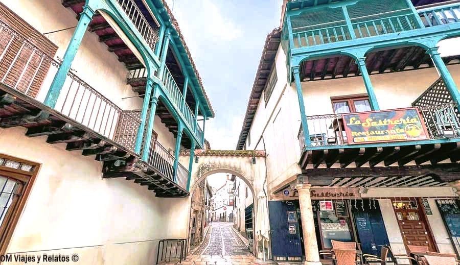 Callejón con soportales y balcones de madera junto al restaurante La Sastrería en Chinchón que ver y donde comer