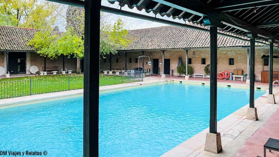Piscina exterior del Parador de Chinchón rodeada de galerías y jardín Chinchón que ver y donde comer