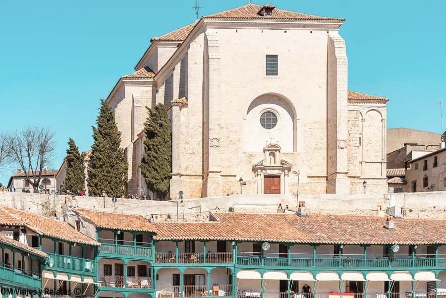 Vista de la iglesia parroquial sobre los soportales de la Plaza Mayor de Chinchón que ver y donde comer
