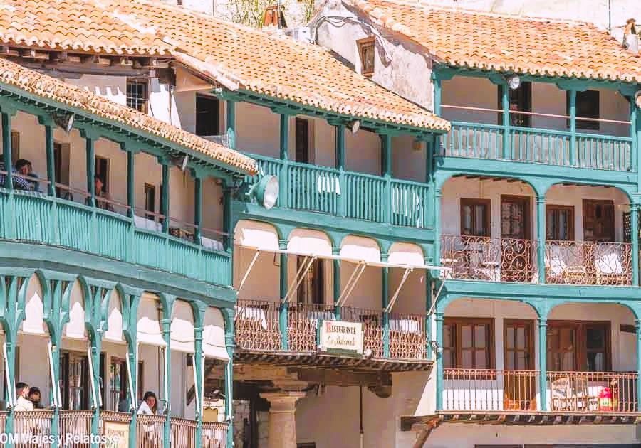 Balcones verdes de madera en la Plaza Mayor de Chinchón con restaurante tradicional, icono de Chinchón que ver y donde comer