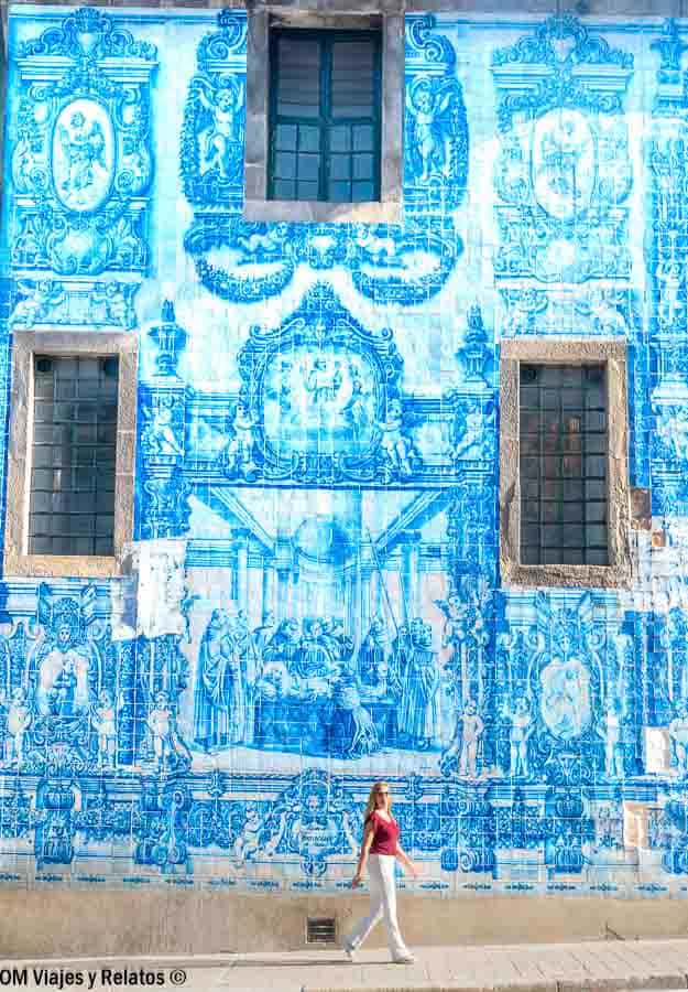 Una servidora caminando frente a una enorme fachada de azulejos azules en Oporto, una de las estampas más fotogénicas que ver en Oporto en 2 días.