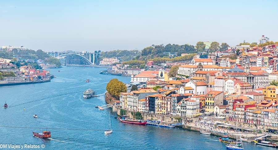 Vista panorámica del río Duero y el barrio de Ribeira en Oporto con barcos y casas de colores, una de las mejores postales que ver en Oporto en 2 días.