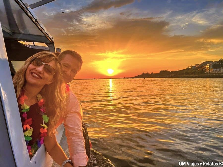 Yo y JC asomados desde un barco al atardecer en Oporto, con el sol reflejándose en el río Duero, una experiencia romántica que ver en Oporto en 2 días.