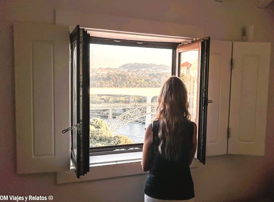 Una servidora contemplando el Puente Don Luis I desde una ventana, una de las vistas imprescindibles que ver en Oporto en 2 días.
