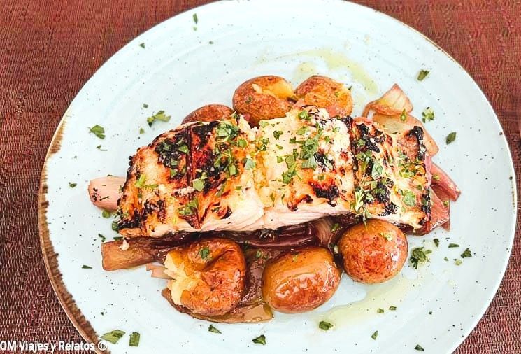 Plato de bacalao a la parrilla con patatas pequeñas y cebolla en un restaurante de Oporto, una comida típica que ver en Oporto en 2 días.