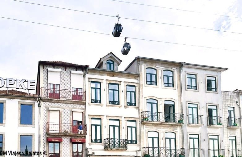 Fachadas del barrio de Ribeira con el teleférico de Vila Nova de Gaia pasando por encima, una vista típica que ver en Oporto en 2 días.