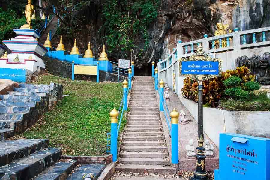 Escaleras con barandillas azules que llevan a la cueva del Templo del tigre Tailandia.