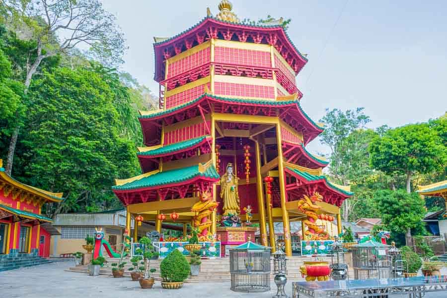 Pagoda roja y dorada con estatua dorada en el Templo del tigre Tailandia.