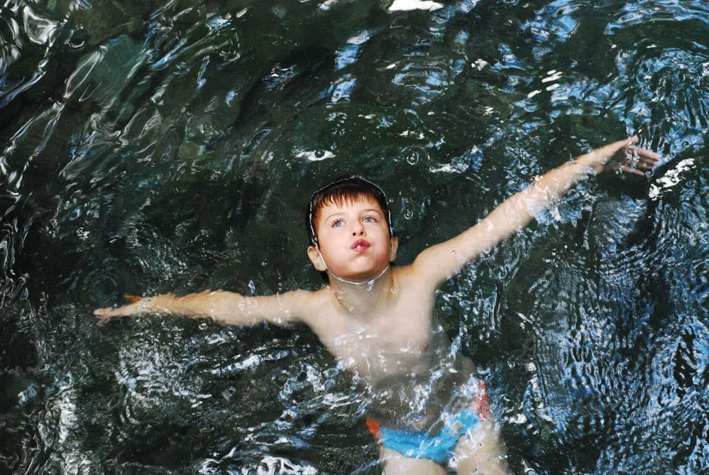 Mi hijo nadando en poza natural durante excursión cerca del Templo del tigre Tailandia