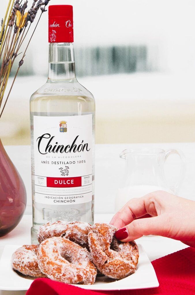 Botella de anís Chinchón dulce junto a plato de rosquillas típicas, imprescindible en cualquier ruta de tapas por el pueblo – Chinchón que ver y donde comer