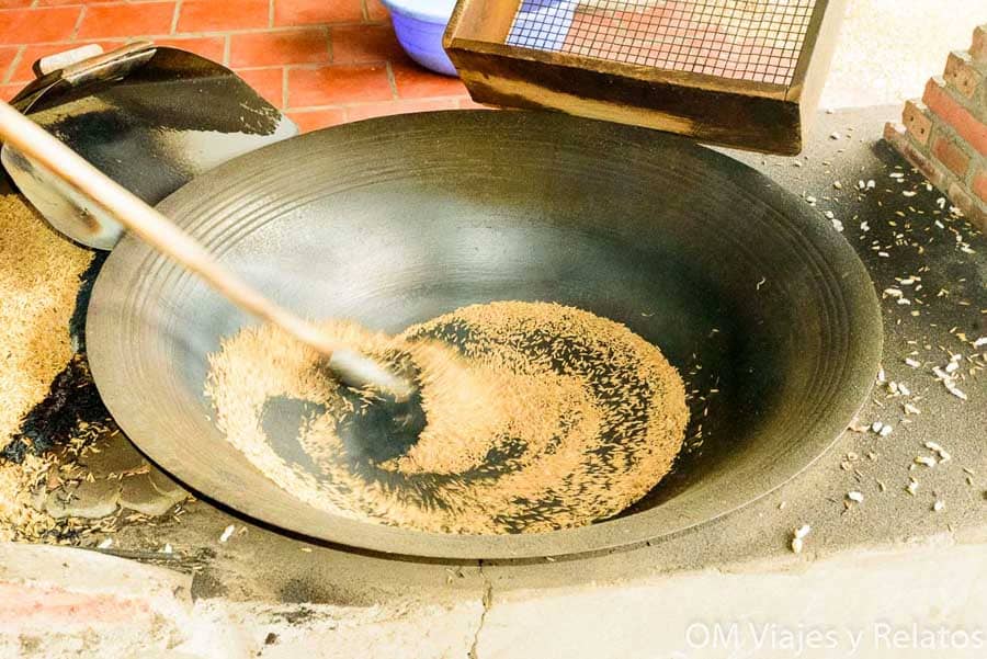 Delta del Mekong Vietnam: tostado tradicional de arroz en gran wok para elaborar productos locales.