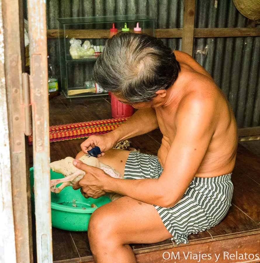 Delta del Mekong Vietnam: artesano local trabajando en una casa tradicional durante una visita cultural.