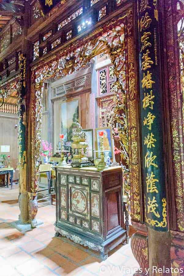 Delta del Mekong Vietnam: interior de templo vietnamita con altar tradicional, tallas de madera y caligrafía dorada.