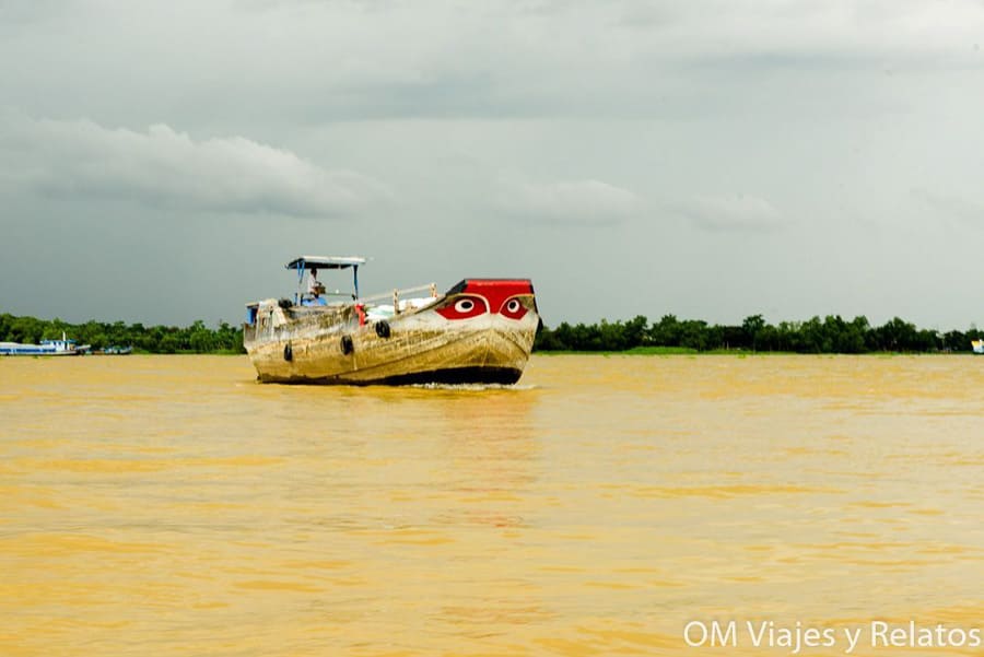 Delta del Mekong Vietnam: barco tradicional con “ojos” pintados navegando por el río entre manglares.
