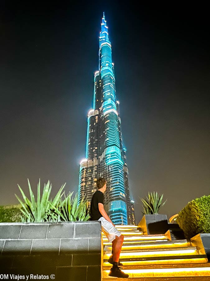 Raúl contemplando el Burj Khalifa iluminado de noche, ideal para compartir en redes si sabes como tener internet en Dubai sin complicaciones.