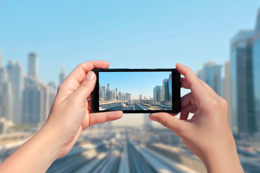 Tomando una foto del skyline de Dubái con el móvil, ejemplo práctico de como tener internet en Dubai durante tu viaje
