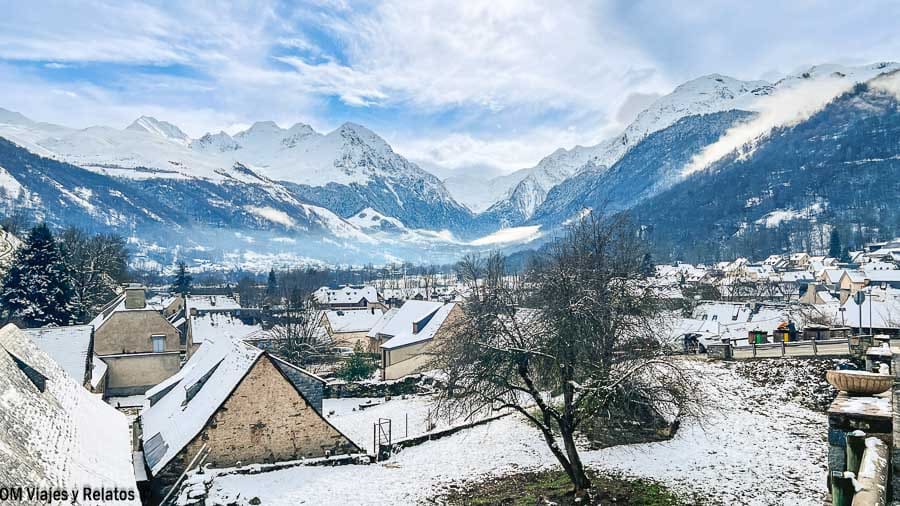 Pueblo del Pirineo Francés cubierto de nieve con casas de tejados blancos y montañas nevadas al fondo, uno de los pueblos más bonitos del Pirineo Francés.