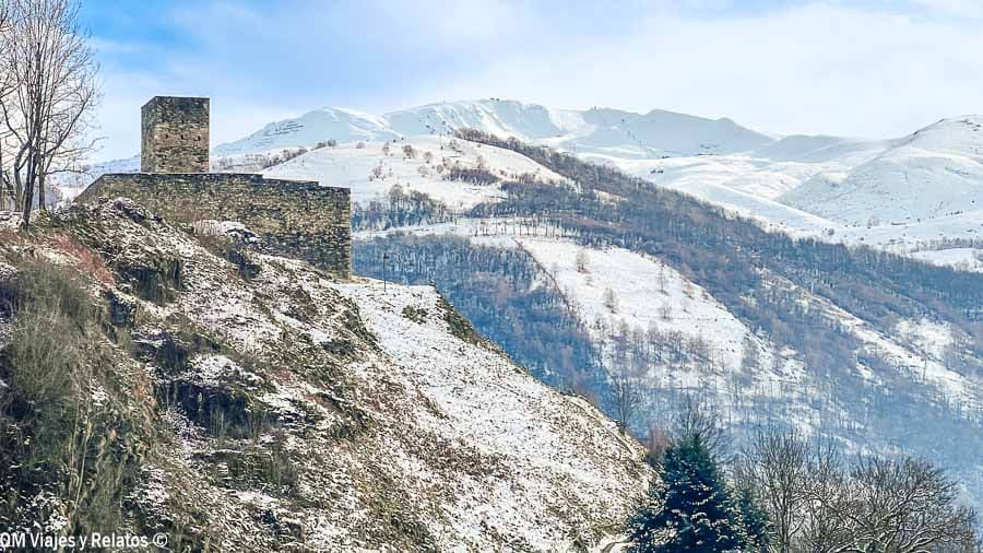 Ruinas de una torre de piedra en una colina con montañas nevadas del Pirineo al fondo, un paisaje de ruta por los pueblos más bonitos del Pirineo Francés.