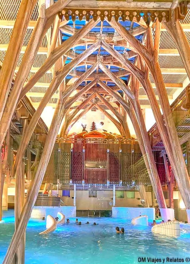 Piscina termal interior en Les Grands Thermes de Bagnères-de-Bigorre con grandes vigas de madera y ambiente de spa, un plan de relax en la ruta por los pueblos más bonitos del Pirineo Francés.