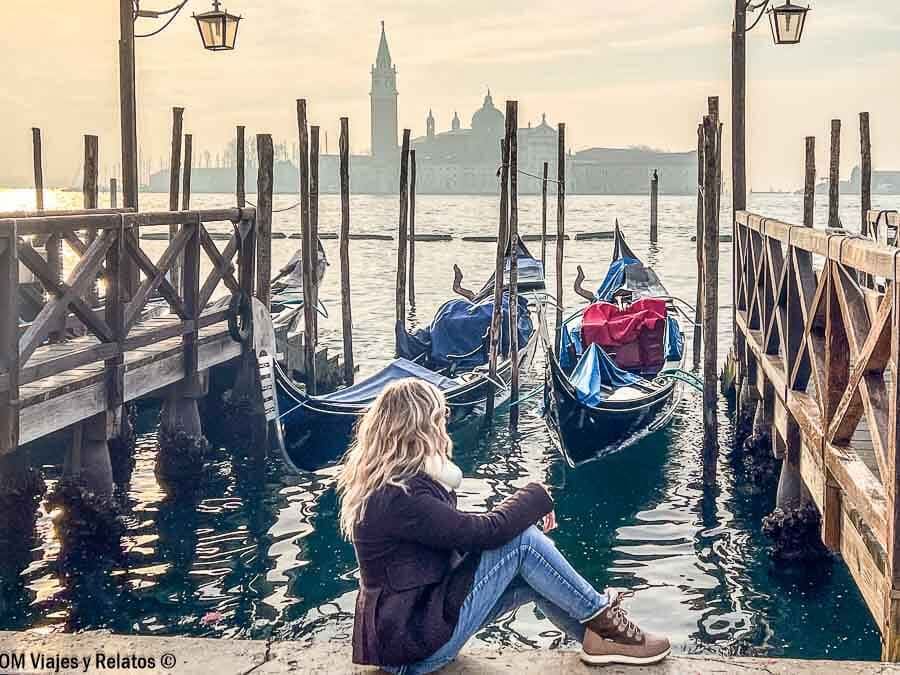 Una servidora posando junto a las góndolas al atardecer con vistas a la isla de San Giorgio Maggiore, uno de los lugares imprescindibles que ver en Venecia en 3 días.