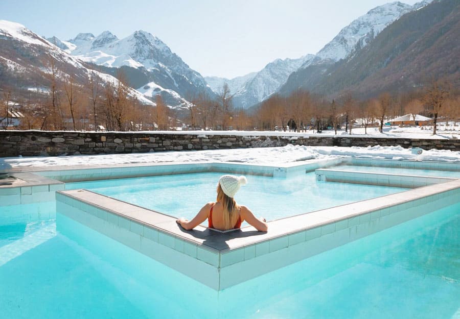 Yo relajándose en las piscinas termales del balneario Balnéa con vistas a montañas nevadas, una experiencia top cerca de los pueblos más bonitos del Pirineo Francés.