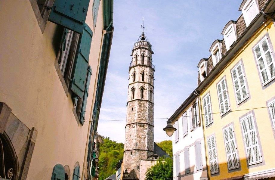 Torre de los Jacobinos en el Pirineo Francés vista desde una calle estrecha con casas y contraventanas, un rincón con encanto de los pueblos más bonitos del Pirineo Francés.