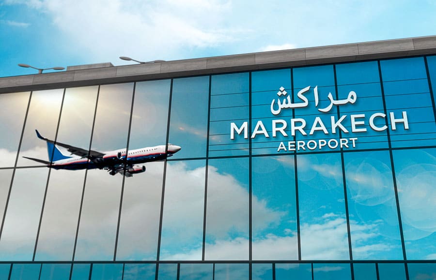 Fachada del Aeropuerto de Marrakech con un avión, útil para consejos para viajar a Marruecos sobre llegada y transporte.