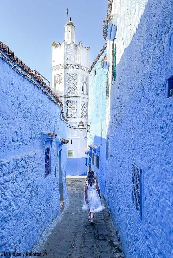 Calle azul de Chefchaouen con foto mía caminando, perfecta para consejos para viajar a Marruecos y visitar la medina.
