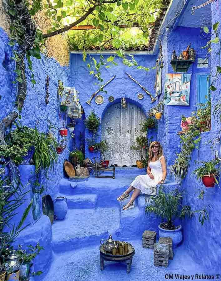 Servidora posando en un patio azul de Chefchaouen, perfecto para consejos para viajar a Marruecos y disfrutar de la ciudad azul.
