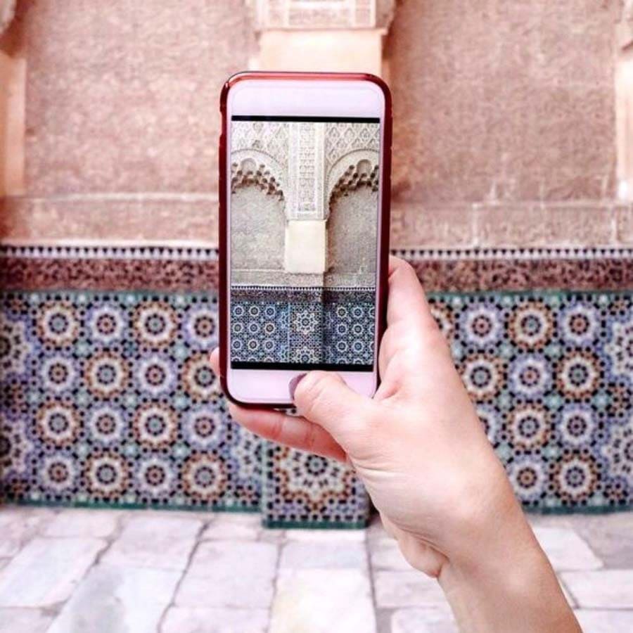 Haciendo una foto con mí móvil a los azulejos de una medina, útil para consejos para viajar a Marruecos y llevar buena conectividad.