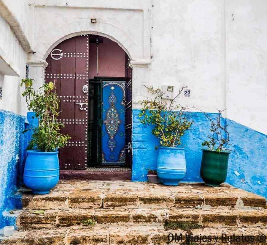 Puerta azul en una calle de la medina con macetas, perfecta para consejos para viajar a Marruecos y pasear con calma.