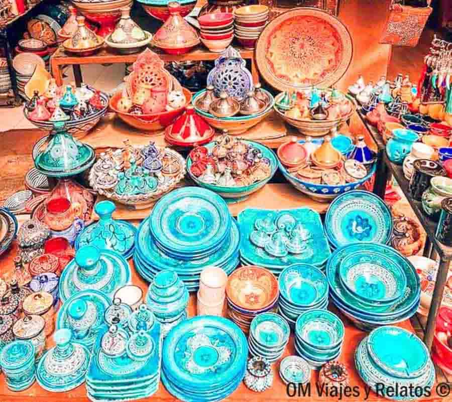 Puestos de cerámica y tajines de colores en un zoco, ideal para consejos para viajar a Marruecos y comprar artesanía.
