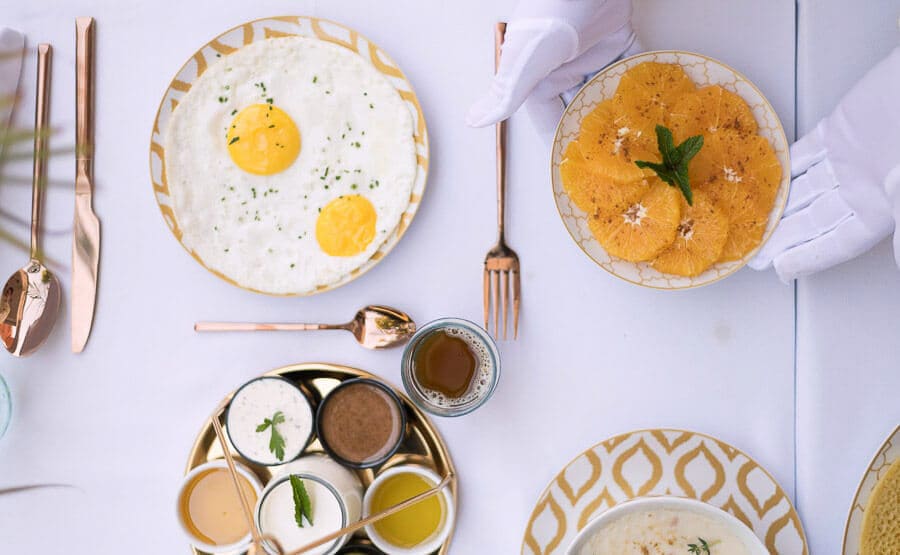 Desayuno marroquí con huevos, naranjas y salsas servido en mesa, plan foodie de qué ver en Marrakech en 4 días.
