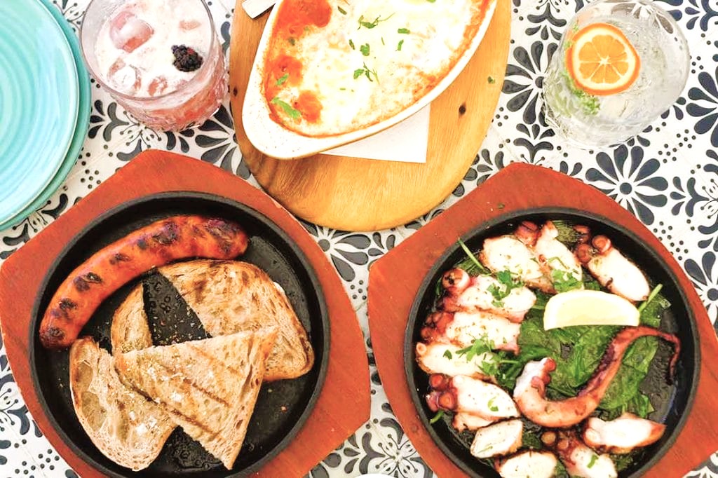 Platos de comida griega con pulpo, salchicha y queso durante nuestra ruta por Atenas