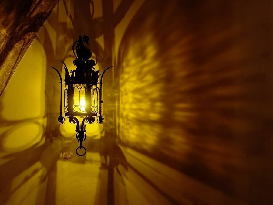 Farol marroquí encendido proyectando sombras en la pared, detalle con encanto de qué ver en Marrakech en 4 días.