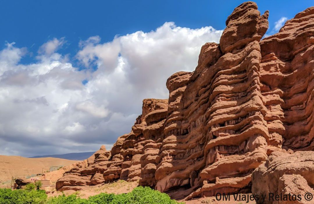 Formaciones rocosas rojizas en un paisaje árido, una parada típica en rutas en coche por Marruecos.