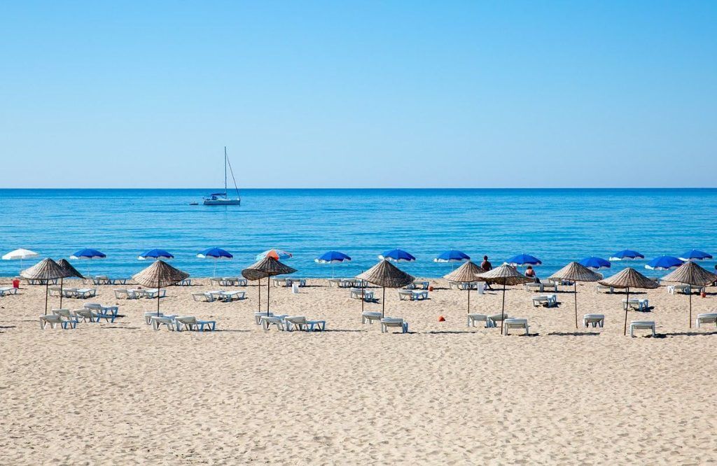 Internet en Turquía para buscar playas y compartir fotos de una costa tranquila con sombrillas y tumbonas frente al mar.