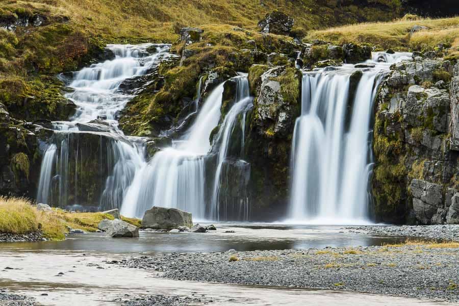 Cascada de varios saltos rodeada de musgo y rocas, un paisaje muy fotogénico de Islandia en octubre.