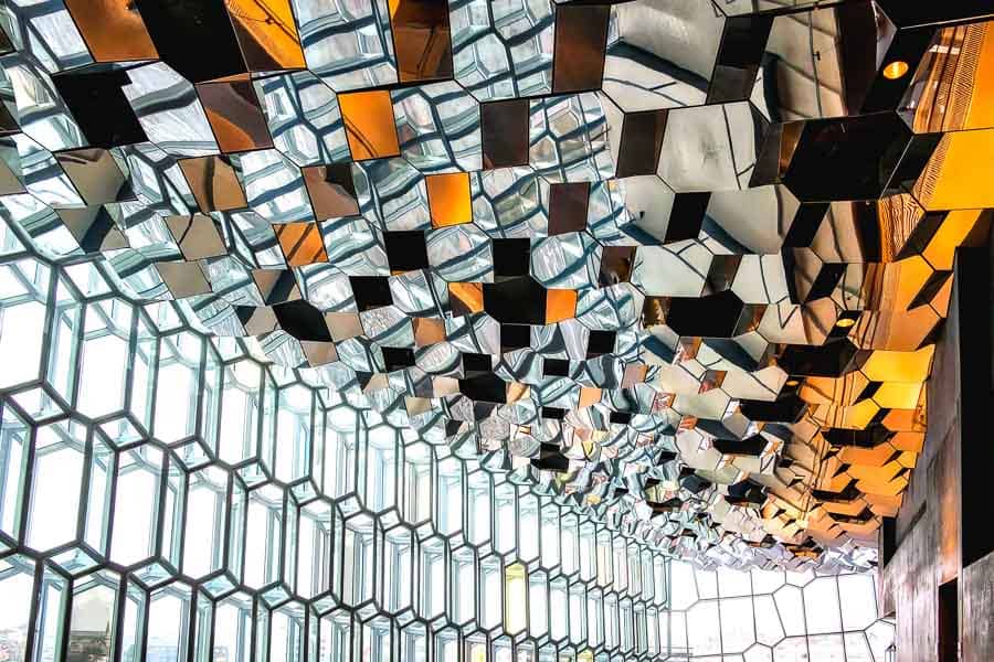Interior del Harpa en Reikiavik con techo espejado y estructura geométrica, un plan genial en Islandia en octubre.