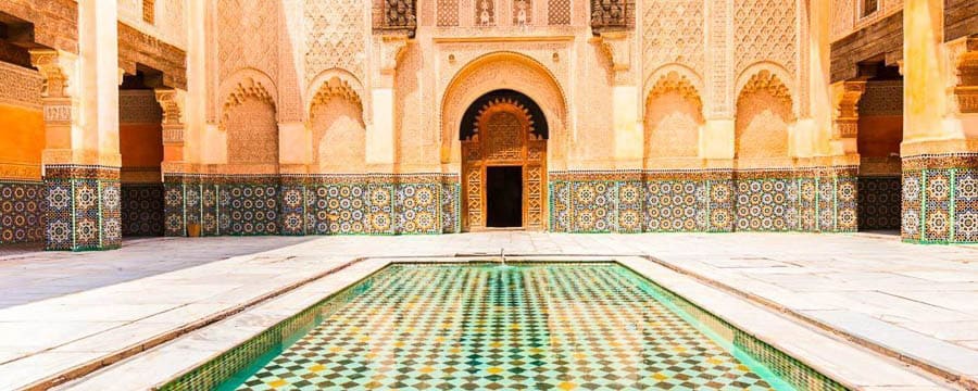Patio con piscina y mosaicos de la Madrasa Ben Youssef, imprescindible en qué ver en Marrakech en 4 días.