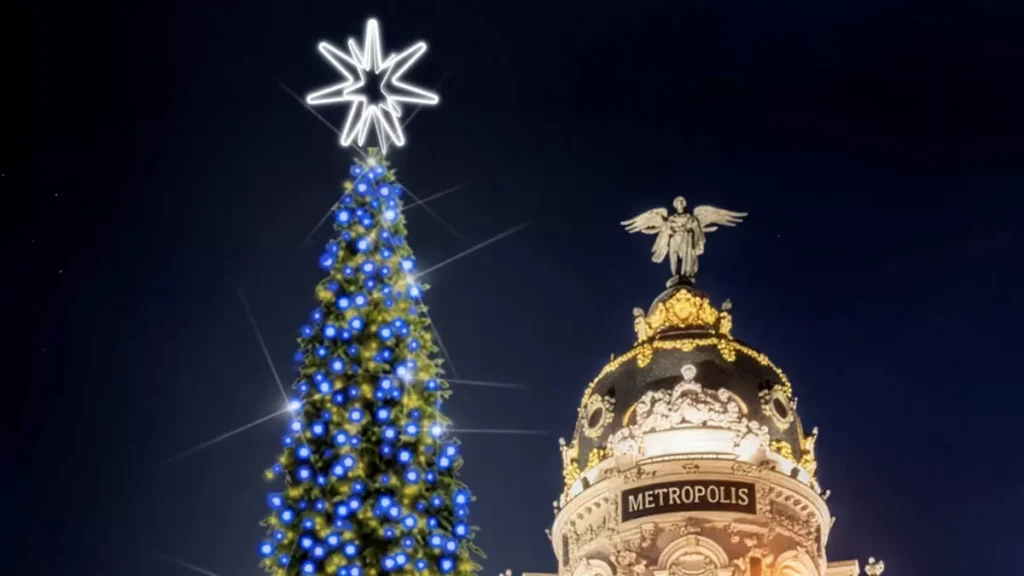 Árbol de Navidad iluminado junto al edificio Metrópolis en Madrid, uno de los planes que hacer en Madrid en Navidad gratis.