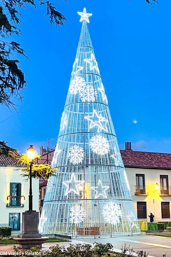Árbol de Navidad gigante iluminado en una plaza de Madrid al atardecer, plan imprescindible que hacer en Madrid en Navidad gratis.