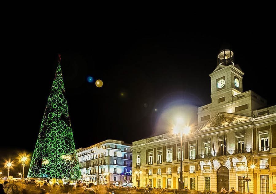 Árbol de Navidad iluminado junto a la Real Casa de Correos en Madrid por la noche, lugar emblemático que hacer en Madrid en Navidad gratis.