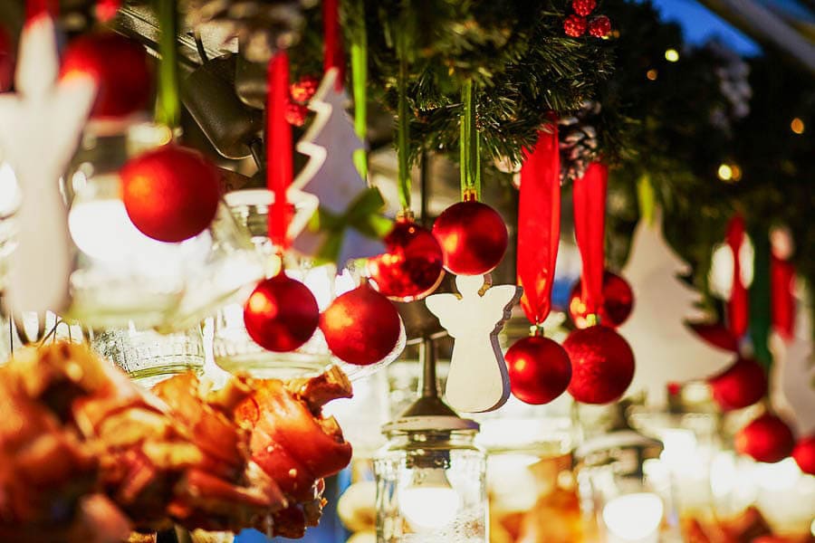 Decoración navideña con bolas rojas y luces en un puesto festivo, ambiente típico que hacer en Madrid en Navidad gratis.