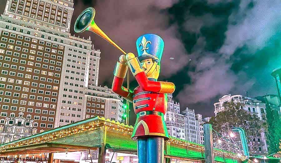 Figura gigante de soldado navideño decorando un mercadillo en Madrid por la noche, plan típico que hacer en Madrid en Navidad gratis.