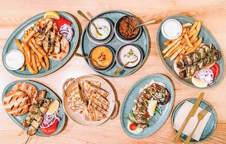Mesa con platos de comida griega en un restaurante de Plaka, plan gastronómico en que ver en Atenas en 3 días.