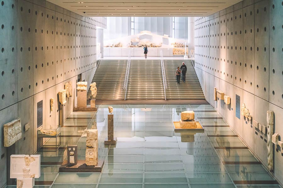 Interior del Museo de la Acrópolis con pasarela de cristal y escaleras, visita top en que ver en Atenas en 3 días.