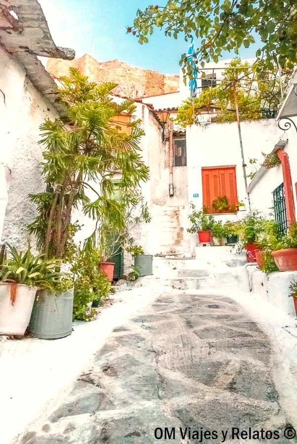 Callejón con casas blancas y macetas en el barrio de Plaka, un paseo con encanto en que ver en Atenas en 3 dias.