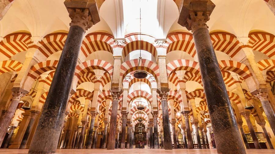 Bosque de columnas y arcos rojos y blancos en el interior de la Mezquita-Catedral de Córdoba, imprescindible en que ver en Córdoba en un día.
